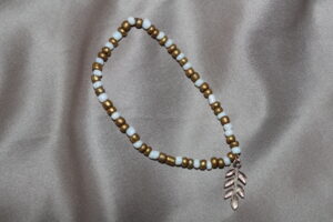 Elastiskt armband med pärlor och berlock