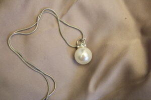 Halsband med silverfärgad kedja och mellanstor pärla