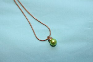 Guldfärgat halsband med ljusgrön pärla